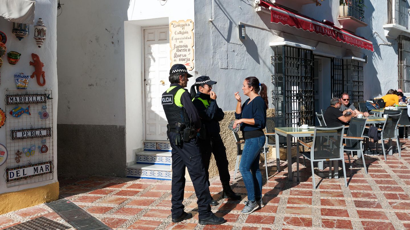 Marbella: Organisierte Kriminalität Zwei Polizisten sprechen auf Marbella mit einer Frau