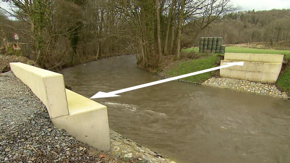 Zwei Widerlager einer Brücke stehen gegenüber voneinander an einem Fluss. Die Entfernung wird mit einem Pfeil visualisiert