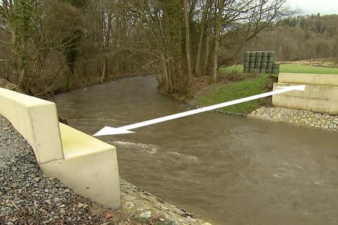 Zwei Widerlager einer Brücke stehen gegenüber voneinander an einem Fluss. Die Entfernung wird mit einem Pfeil visualisiert