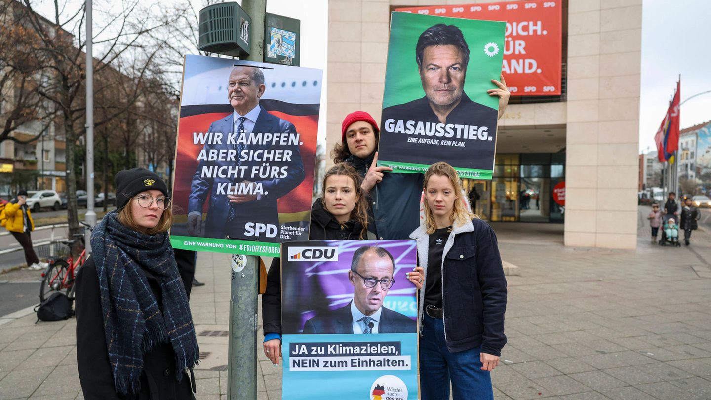 Umweltaktivisten von Fridays for Future posieren mit kritischen Wahlplakaten vor der Bundestagswahl