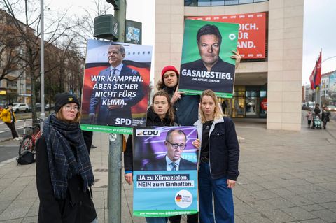 Umweltaktivisten von Fridays for Future posieren mit kritischen Wahlplakaten vor der Bundestagswahl