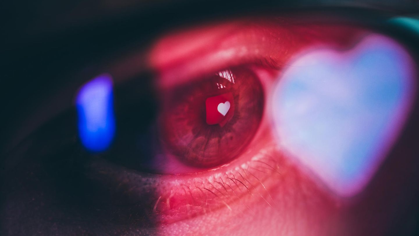 Ein Herz spiegelt sich in einem rot angeleuchteten Auge