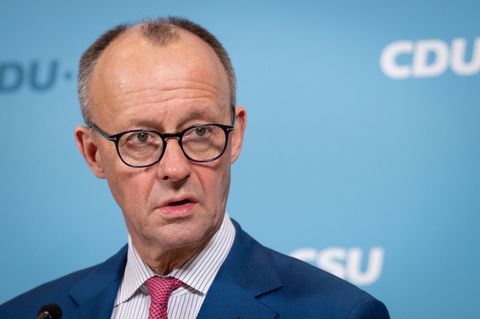Friedrich Merz trägt ein Jackett und schaut in die Kamera.