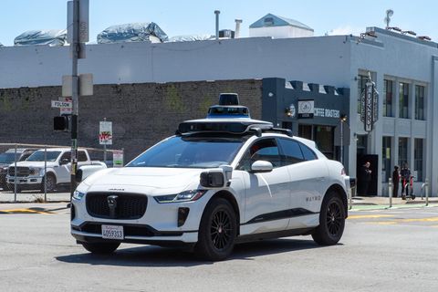 Ein weißes Auto der Marke WAYMO fährt auf einer amerikanischen Straße