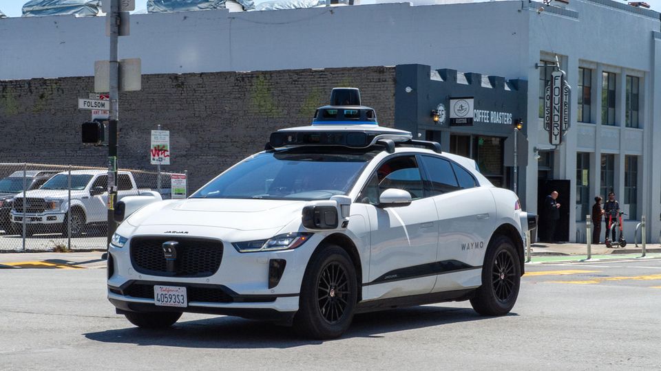 Selbstfahrendes Taxi fährt samt Fahrgast minutenlang im Kreis Ein weißes Auto der Marke WAYMO fährt auf einer amerikanischen Straße