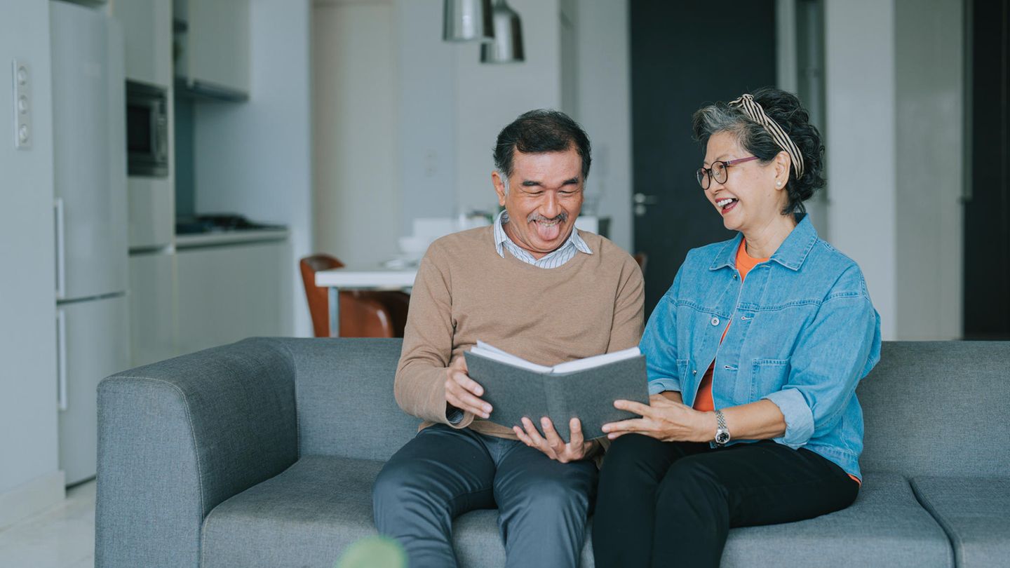 Ein Mann und eine Frau lesen witzige Bücher zum Verschenken.