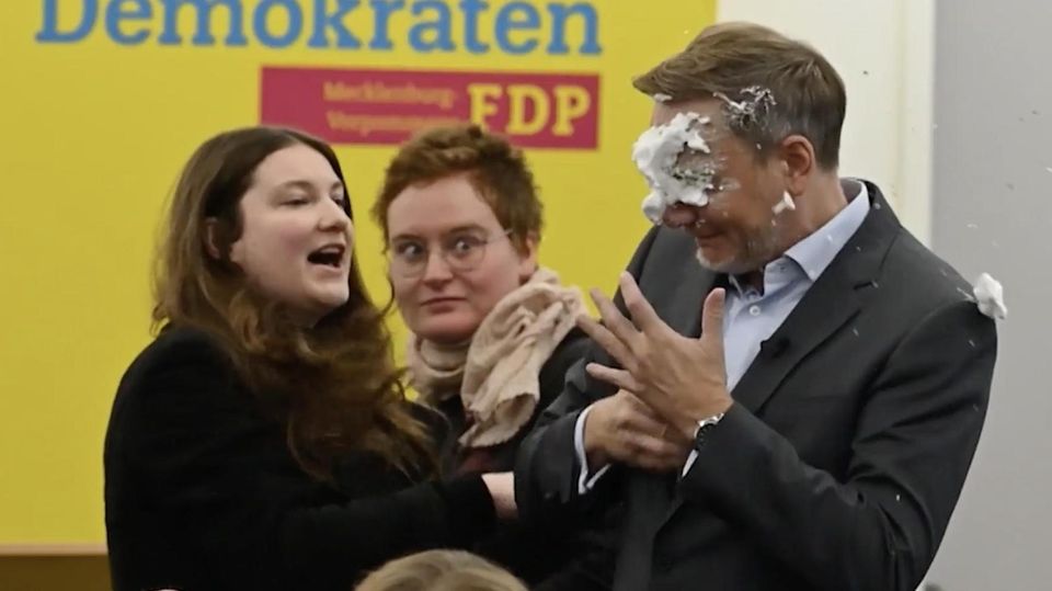 Eine linke Lokalpolitikerin bewirft FDP-Parteichef Christian Lindner mit einer Schaumtorte