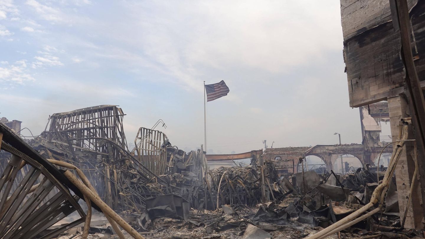 Es sieht aus wie in der Apokalypse: Über einem niedergebrannten Haus in Pacific Palisades weht Donnerstag eine US-Flagge. Auf mindestens 9000 zerstörte Gebäude beziffert die Feuerwehr den Schaden am Freitagmorgen