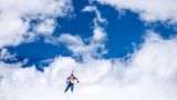 Sportfoto: Eine Biathletin vor einem blauen Wolkenhimmel