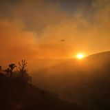 Was wie ein schöner Sonnenuntergang aussieht, ist der Rauch des Kenneth-Feuers im Stadtteil West Hills von Los Angeles, durch den Donnerstag ein Hubschrauber fliegt