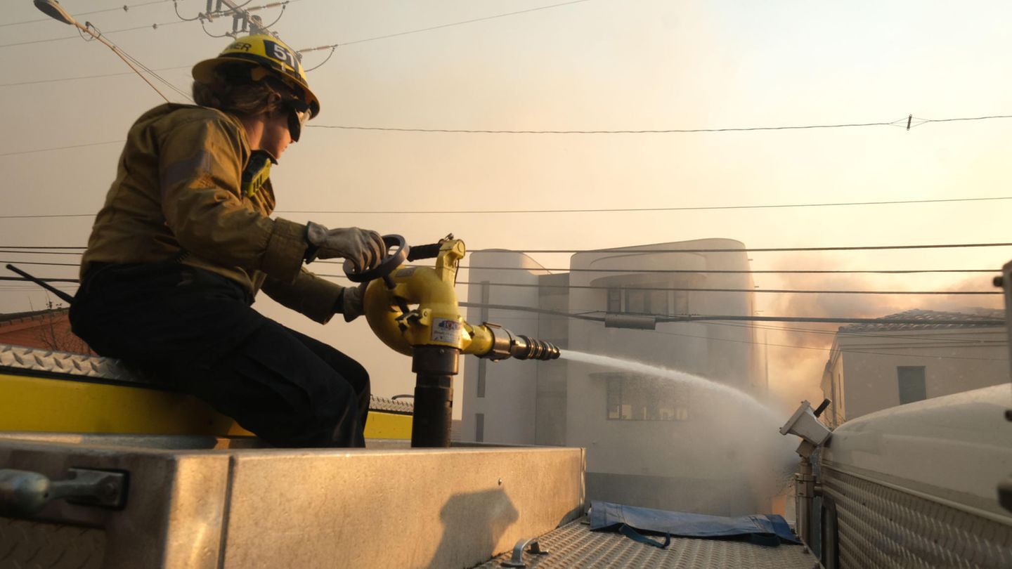 Am Boden versucht dieser Feuerwehrmann, das Übergreifen des Feuers von einem Haus auf das andere in Pacific Palisades zu verhindern