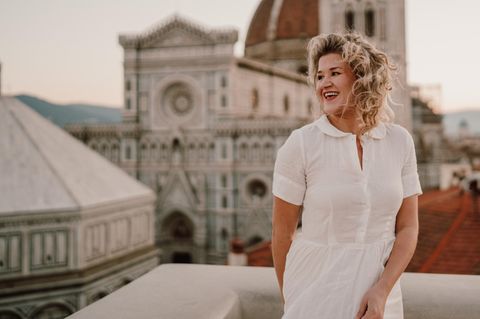 Kacie Rose steht vor dem Dom zu Florenz auf einer Dachterrasse in Italien