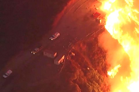 Feuerwehrleute fliehen vor riesiger Flammenwand