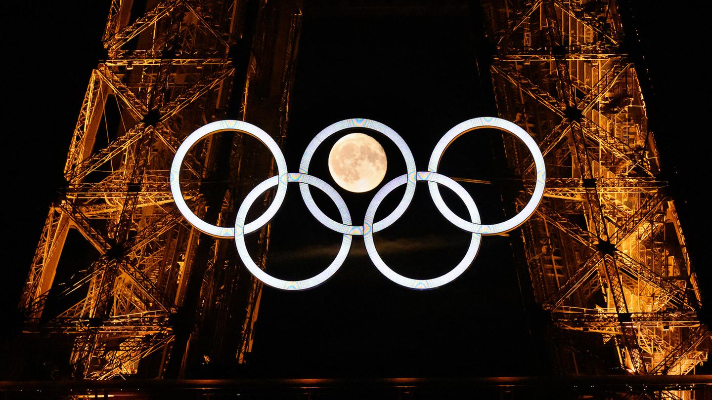 Sportfoto: Die Olympischen Ringe am Eiffelturm in Paris, dahinter der Mond