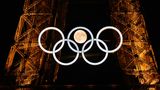 Sportfoto: Die Olympischen Ringe am Eiffelturm in Paris, dahinter der Mond