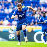 Sportfoto: Ein Fußballerspieler verfolgt den Ball, doch eine Taube kommt ihm in die Quere