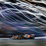 Sportfoto: Ein Formel1-Rennwagen fährt vor einem verschwommenen Hintergrund mit Lichtern