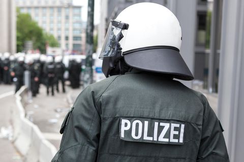 Thema Polizeigewalt Rückansicht eines Polizisten von der Bereitschaftspolizei mit weißem Helm