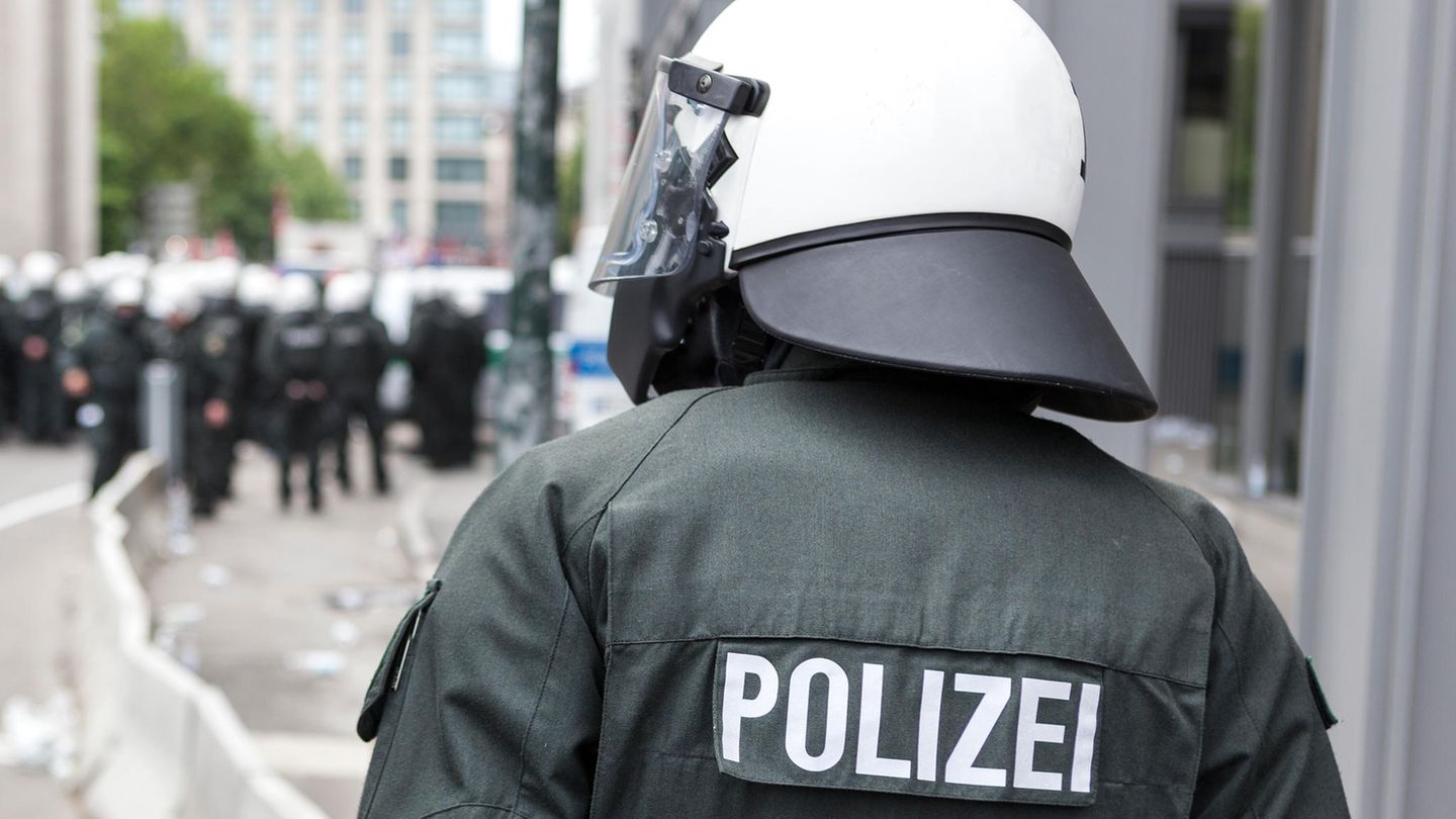 Thema Polizeigewalt Rückansicht eines Polizisten von der Bereitschaftspolizei mit weißem Helm Thema Polizeigewalt Rückansicht eines Polizisten von der Bereitschaftspolizei mit weißem Helm