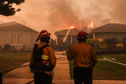 Feuerwehrleute vor einem brennenden Haus in Los Angeles