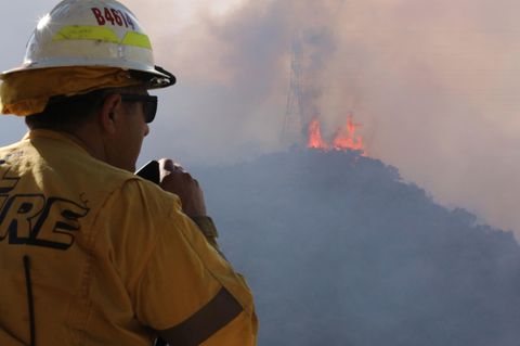 Ein Feuerwehrmann beobachtet lodernde Flammen auf einem Hügel in Los Angeles