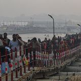 In Prayagraj ankommende Hindus überqueren eine schmale Brücke