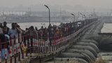 In Prayagraj ankommende Hindus überqueren eine schmale Brücke