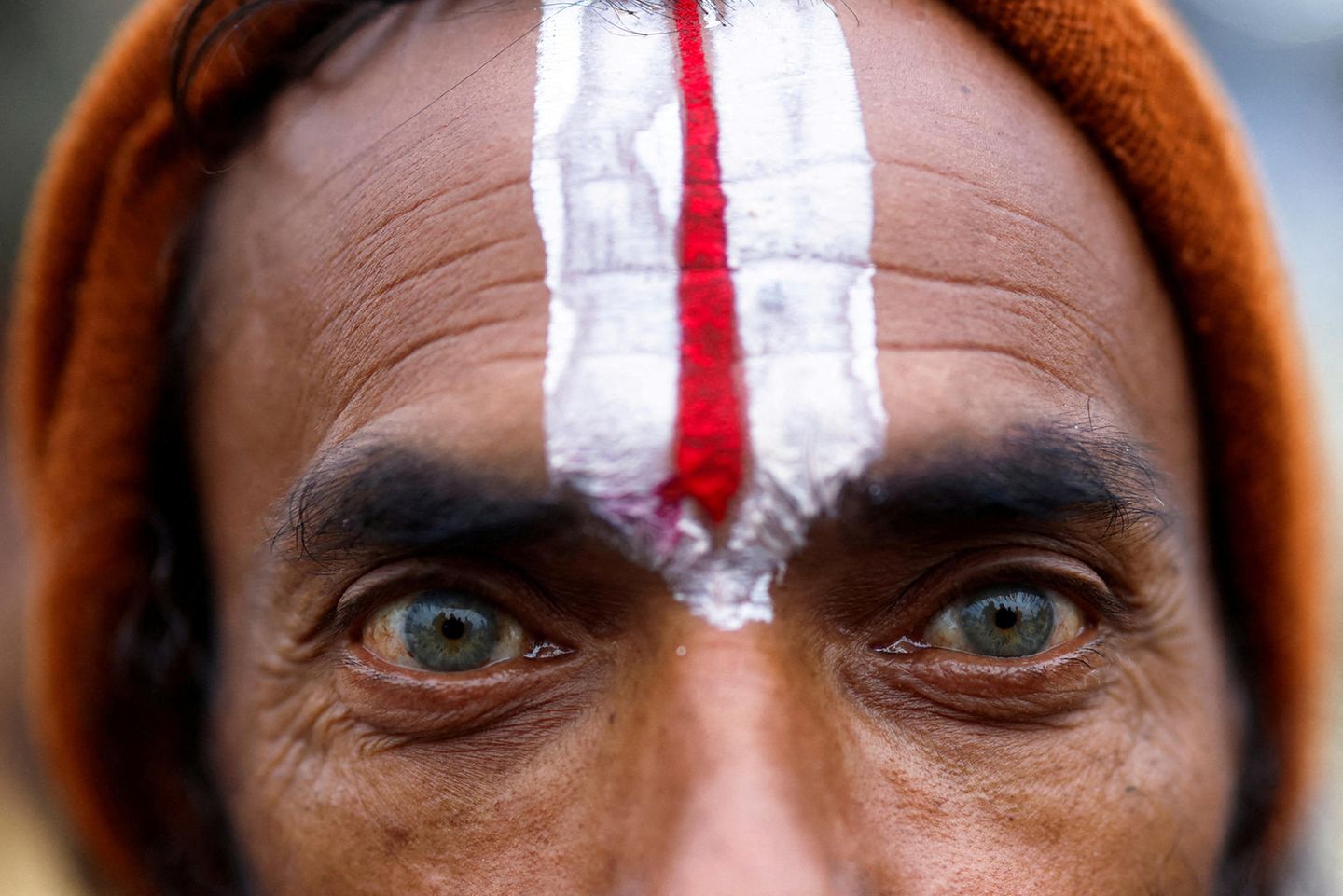 Nahaufnahme der Augen eines Teilnehmers mit einem auf die Stirn gemalten Zeichen Nahaufnahme der Augen eines Teilnehmers mit einem auf die Stirn gemalten Zeichen