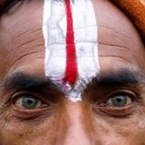 Nahaufnahme der Augen eines Teilnehmers mit einem auf die Stirn gemalten Zeichen