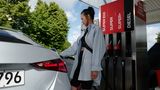 Eine junge Frau beim Tanken ihres Wagens