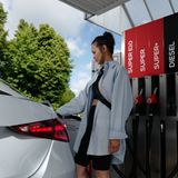 Eine junge Frau beim Tanken ihres Wagens