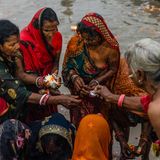 Eine Gruppe von Pilgerinnen vollzieht ein Ritual am Ufer des Flusses