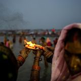 Pilger führen in der Dämmerung ein Ritual am Fluss durch