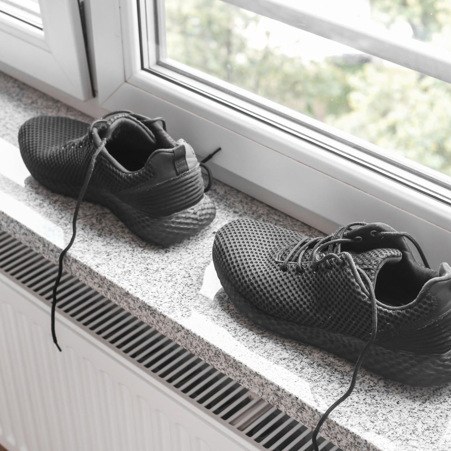 Schuhe trocknen: Paar Barfußschuhe steht auf der Fensterbank über einer Heizung
