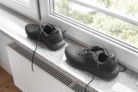 Schuhe trocknen: Paar Barfußschuhe steht auf der Fensterbank über einer Heizung