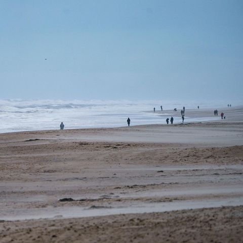 Spaziergänger gehen am Strand von Sylt entlang