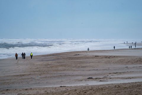Spaziergänger gehen am Strand von Sylt entlang