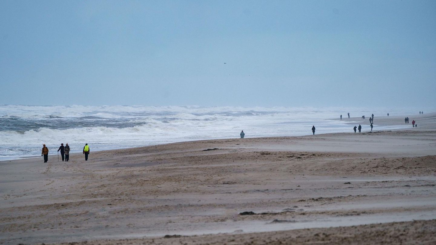 Spaziergänger gehen am Strand von Sylt entlang