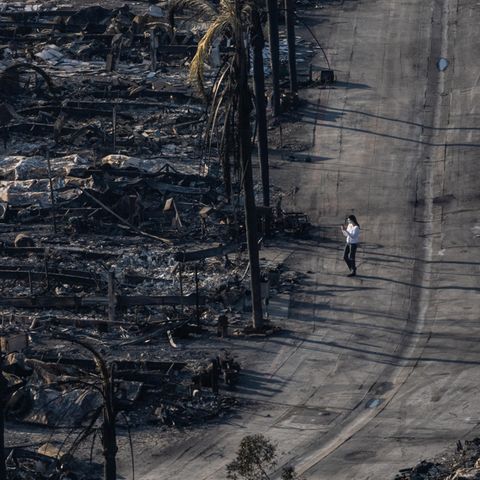 A woman runs through the burned -down neighborhood