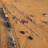 Ein kleines Lager aus der Vogelperspektive: Umgeben von Fahrzeugen und Fahnen, mitten im endlosen Nichts