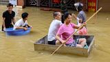 Naturkatastrophen Menschen retten sich mit Schüsseln vor den Wassermassen