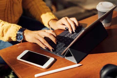 Tastatur für iPad: Eine Frau sitzt am iPad und tippt auf der Tastatur einen Text