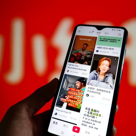 Eine Hand hält ein Smartphone, auf dem der Feed der Tiktok-Alternative Rednote gezeigt wird