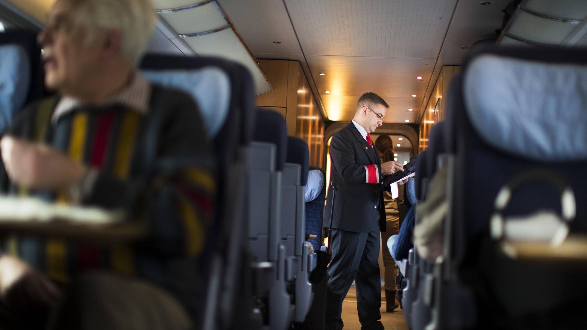 Ein Bahn-Mitarbeiter im Zug kontrolliert Tickets