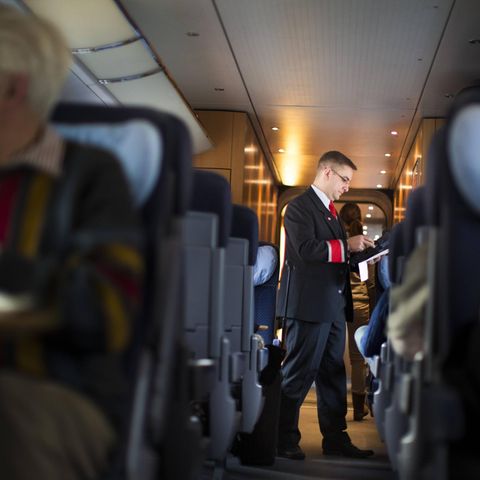 Ein Bahn-Mitarbeiter im Zug kontrolliert Tickets