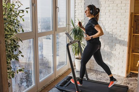 Frau joggt auf kompaktem Laufband für zu Hause