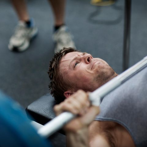 Ein Mann macht Bankdrücken im Fitnessstudio