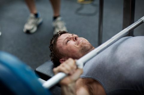 Ein Mann macht Bankdrücken im Fitnessstudio
