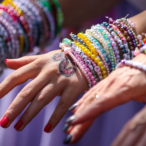 Um die Handgelenke zweier Taylor-Swift-Fans sind etliche Freundschaftsarmbänder gebunden