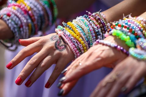 Um die Handgelenke zweier Taylor-Swift-Fans sind etliche Freundschaftsarmbänder gebunden